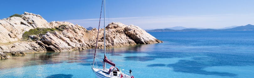 A sailboat is anchored on the crystal clear water of Santa Teresa di Gallura, Sardinia.