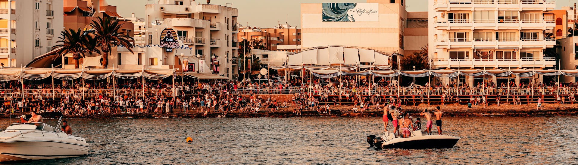 Deux bateaux avec des personnes s'amusant lors d'une promenade en bateau vers le Cafe Mambo et le Cafe del Mar.
