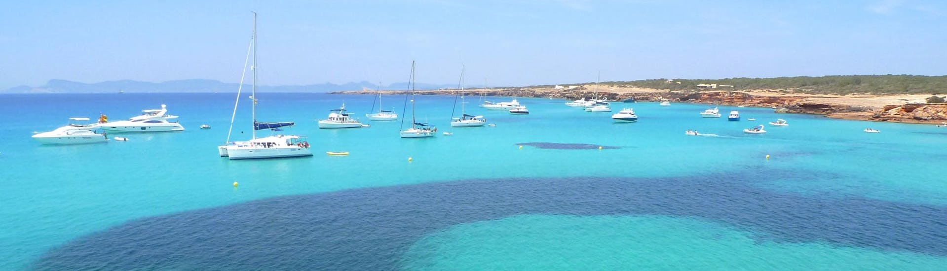 Meerdere boten langs de kust tijdens een boottocht naar Formentera.