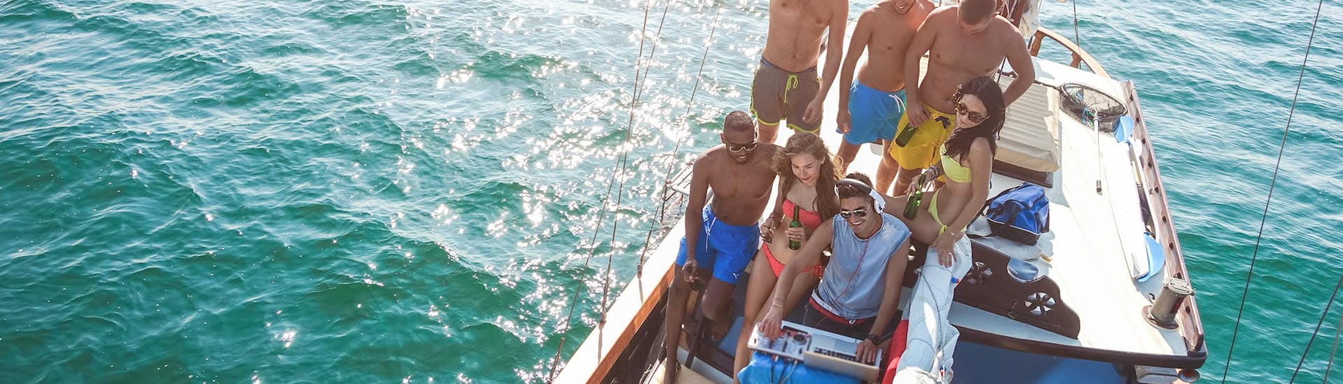 Un gruppo di amici si diverte in una gita in barca con musica dal vivo e dj.