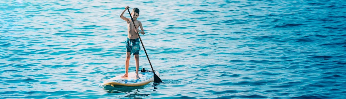 Gite in barca con SUP incluse SEM Hero Un bambino su una tavola durante una gita in barca con tavole da SUP incluse a bordo.