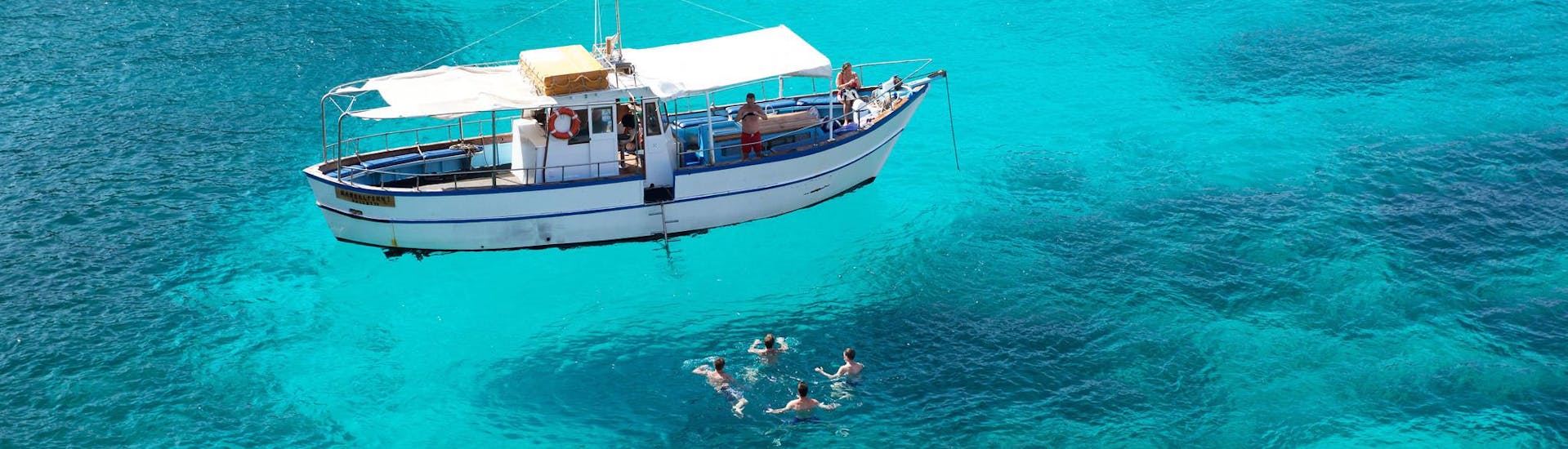 Gente divirtiéndose durante un paseo en barco con paradas para nadar.