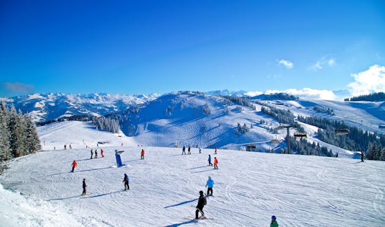 Adults and kids skiing in Brixen im Thale ski resort.