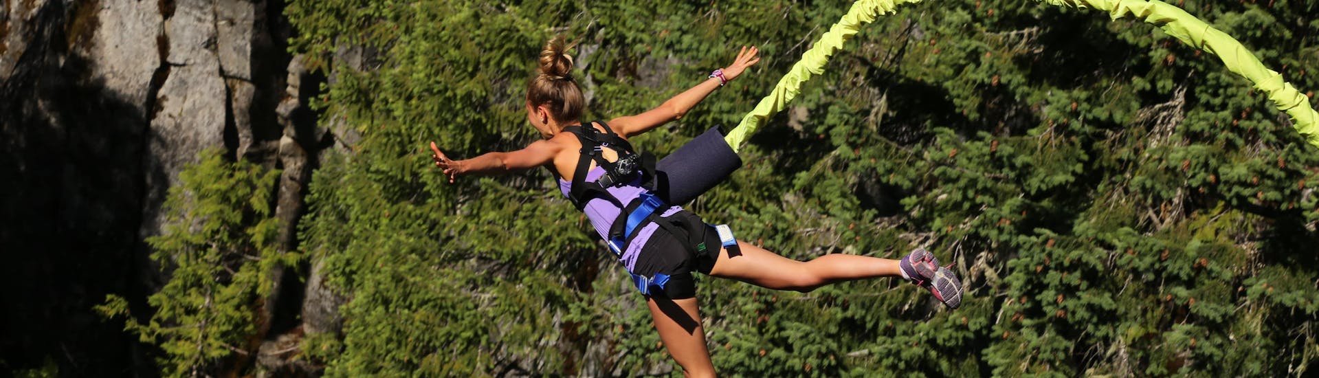 Una giovane donna salta con il bungee jumping presso Les Eyzies.