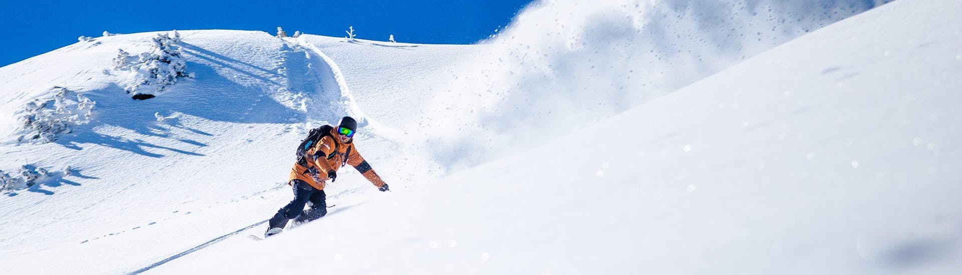 Ein Snowboarder gleitet bei einem Snowboardkurs mit Cab9 Snowboarding im Skigebiet Val Thorens eine Pulverschneepiste hinunter.