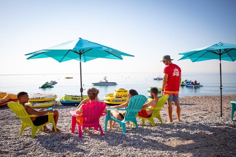 Des amis sont assis sur la plage de Cagnes-sur-Mer et attendent de commencer leur activité nautique avec Cagnes Watersports.