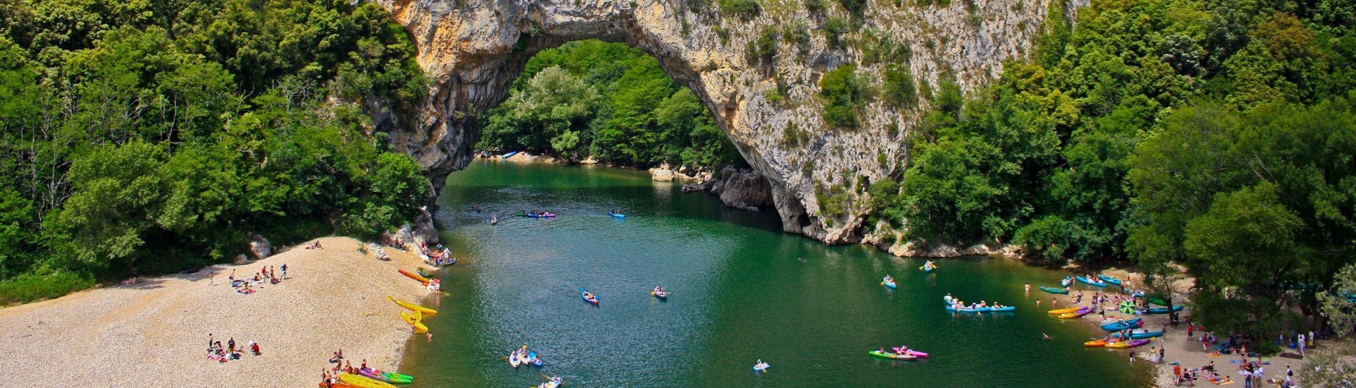 A mother and her two children are paddling across the water as they enjoy their kayak canoe in Saint-Martin-d'Ardèche.