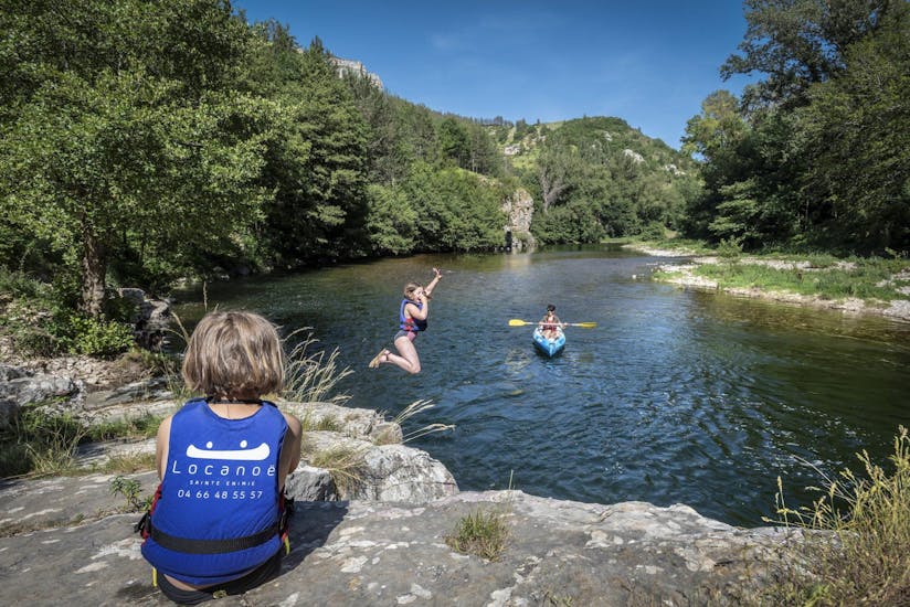 Des adultes et un enfant s'amusant en sautant dans l'eau lors de leur excursion en kayak dans les Gorges du Tarn avec Lo Canoë Gorges du Tarn.
