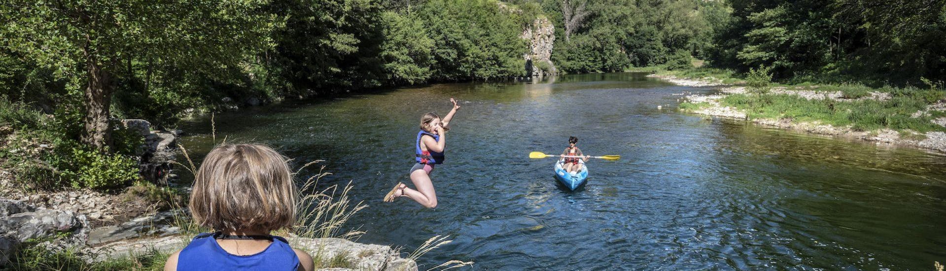Des adultes et un enfant s'amusant en sautant dans l'eau lors de leur excursion en kayak dans les Gorges du Tarn avec Lo Canoë Gorges du Tarn.
