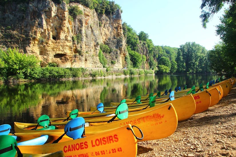 Des canoës vides de Canoës Loisirs attendent les vacanciers sur les bords de la Dordogne au petit matin, pour une balade en canoë le long de la rivière.