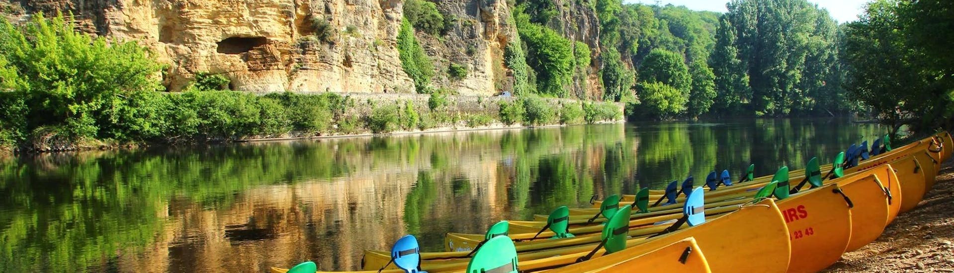 Empty canoes from Canoës Loisirs await holidaymakers on the banks of the Dordogne in the early morning for a canoe trip along the river.