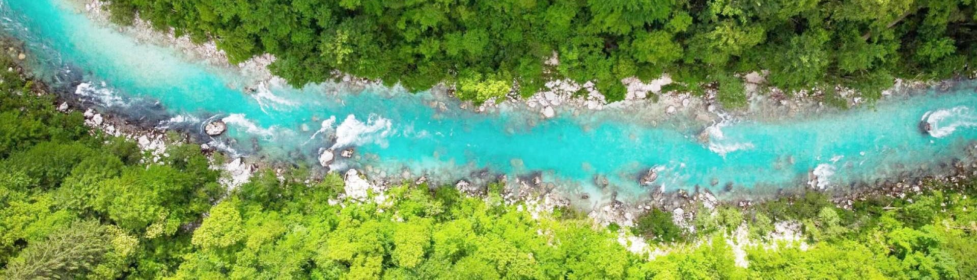 Aerial view of a river and its surrounding forest, ideal for a canyoning trip.
