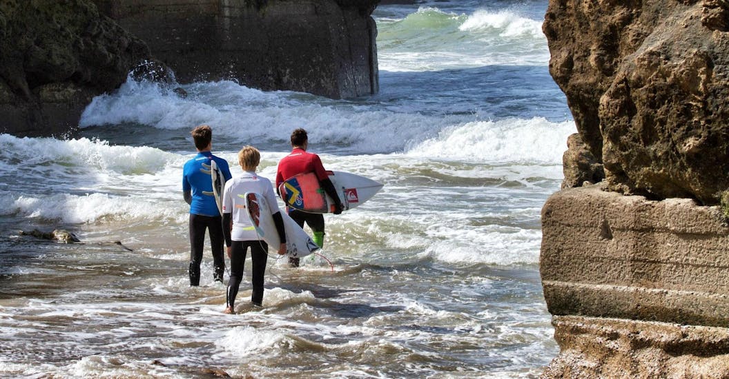 Trois surfeurs se dirigent vers la mer pour leurs cours de surf avec Capbreton Surfer School.
