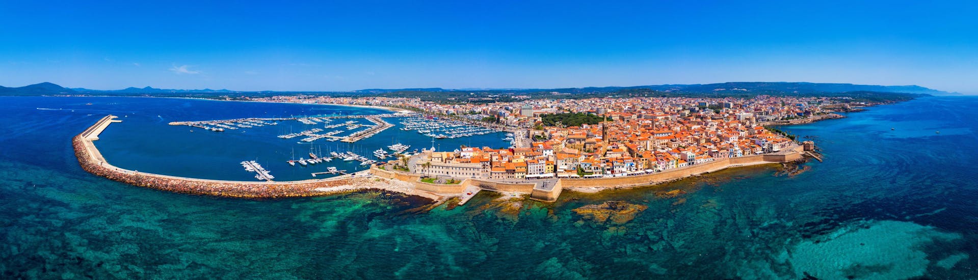 Blick auf die Stadt Alghero, ein beliebter Ort für Bootstouren auf Sardinien.