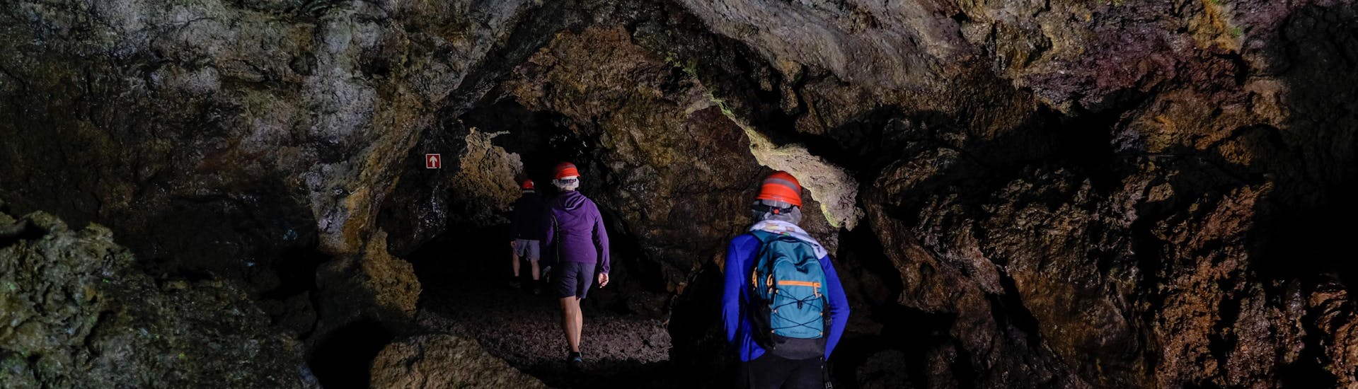 Eine Gruppe von Menschen, die während einer Höhlenwanderung unter die Erde gehen.