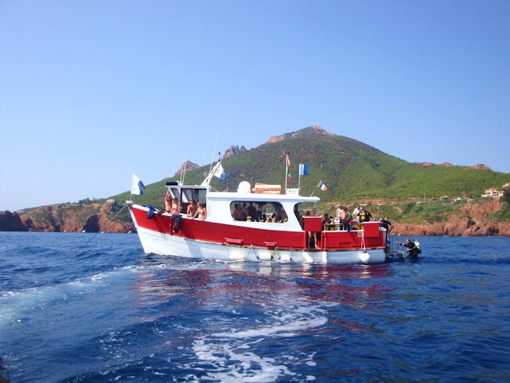 View of the Dive Center La Rague boat in front of the Estérel massif used for snorkeling trips and diving courses near Cannes.