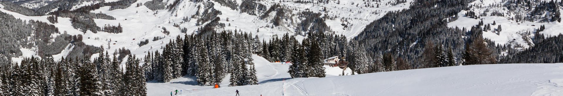 Adults and kids skiing in Corvara ski resort.