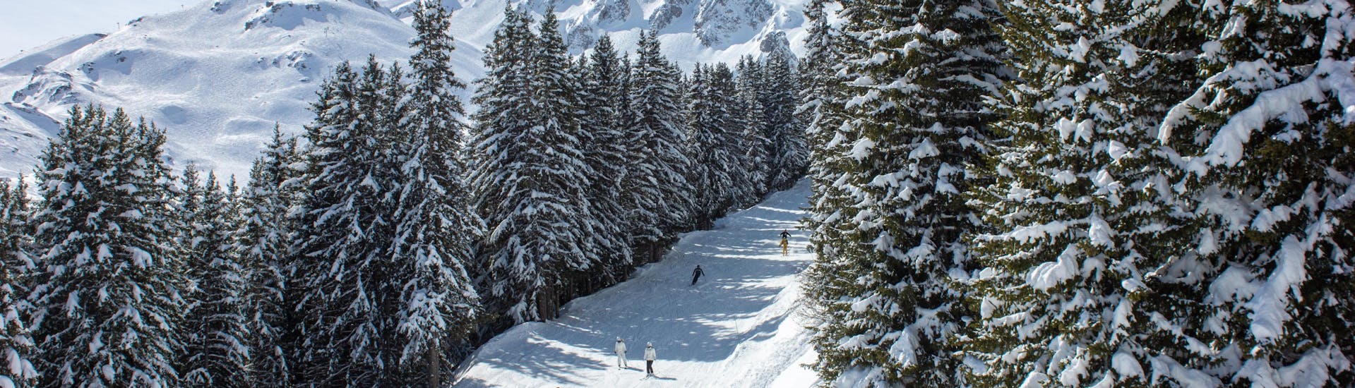 Menschen genießen das Skifahren an einem sonnigen Tag im Skigebiet Courchevel 1650.