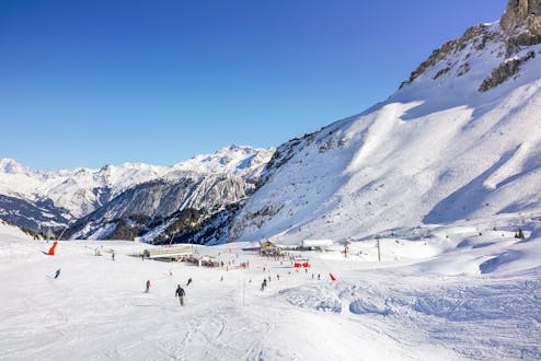 Menschen genießen das Skifahren an einem sonnigen Tag im Skigebiet Courchevel 1850.
