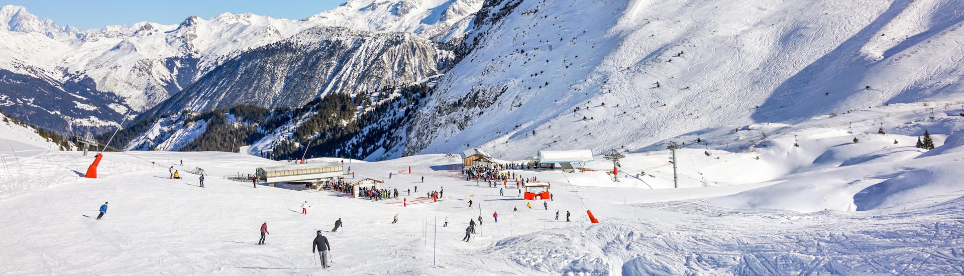 People enjoy skiing during a sunny day in Courchevel 1850 ski resort.