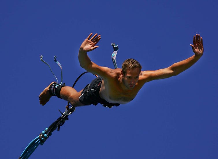Foto en primer plano de un hombre participando en el salto de puenting desde Bungee Site Zrce.