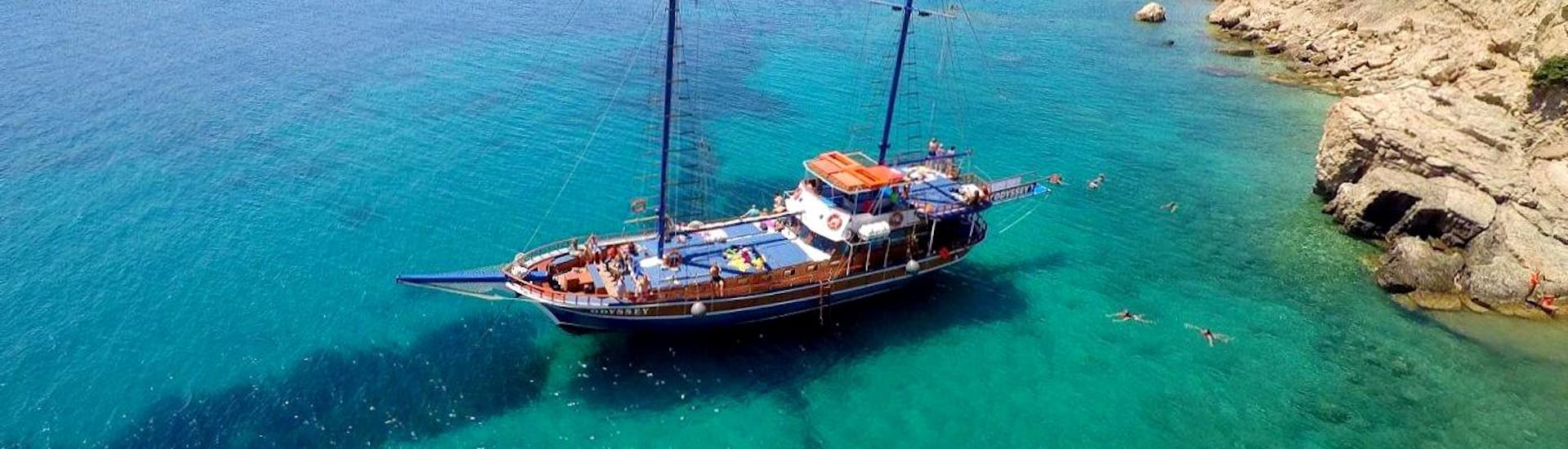 An elegant sailboat with participants enjoying a day out in the Greek waters during a sailing boat trip to the islands Kalymnos, Plati & Pserimos with Odyssey Boat Kos.