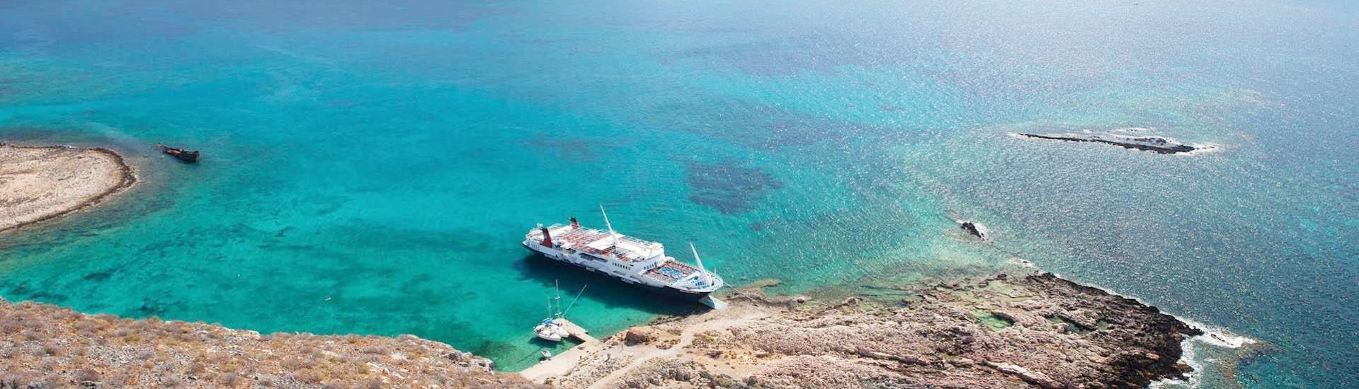 A boat used by Cretan Daily Cruises on the water, anchored along the coast of Crete.