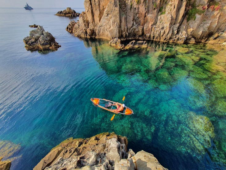 Transparent bottom kayak in the middle of sea next to Blanes from Crystal Kayak Blanes Rental.