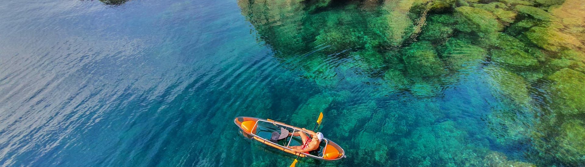 Transparent bottom kayak in the middle of sea next to Blanes from Crystal Kayak Blanes Rental.