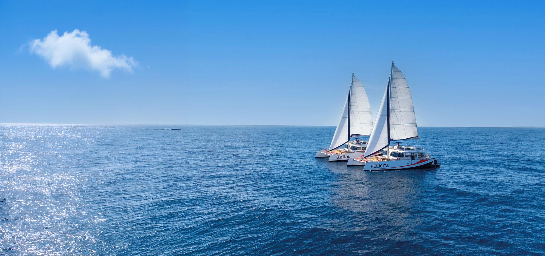 Deux maxi-catamarans d&#x27;AMC Cape Grace sur les eaux bleu turquoise de la Méditerranée.