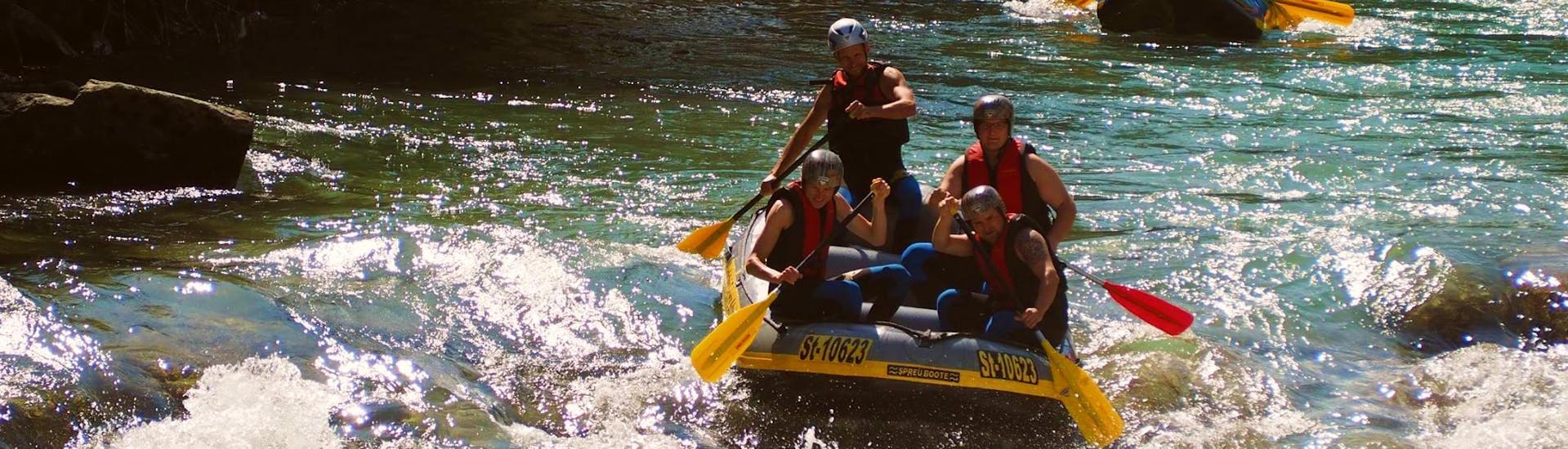 A group of friends is enjoying their rafting tour on the Enns river with Dachstein Tauern Adventure.