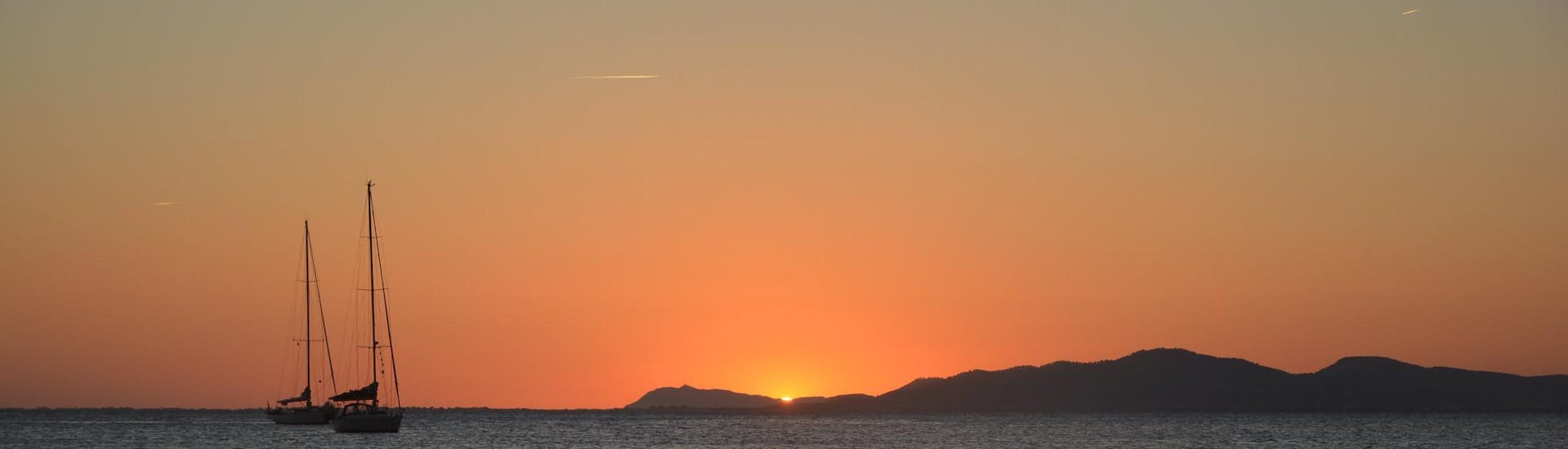 Zwei Boote während eines Tagesausflugs mit Menschen, die einen schönen Sonnenuntergang genießen.