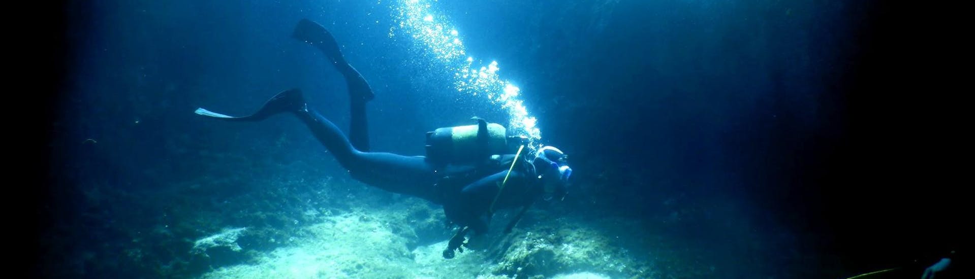 Un plongeur nage dans une caverne sous-marine durant une plongée d'exploration avec Dive Easy à Corfou. 