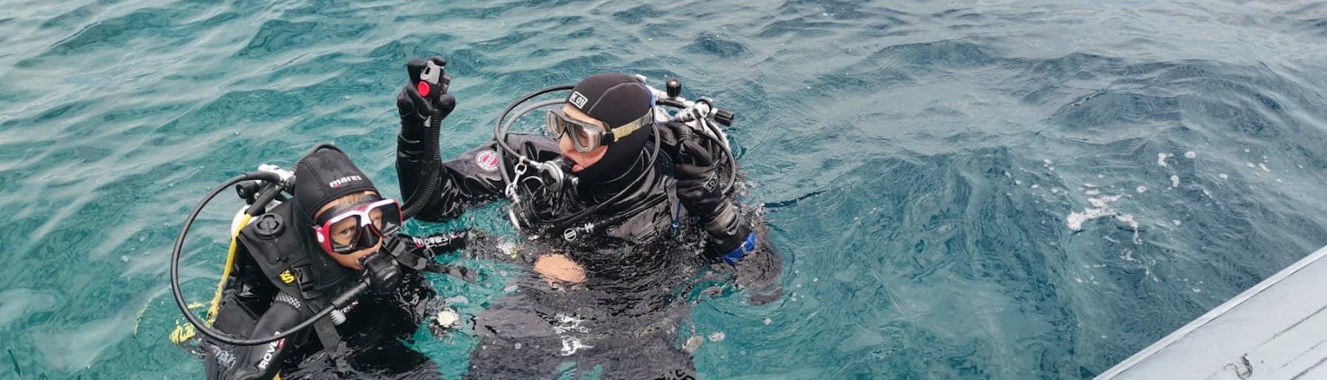A child and a diving instructor in the water during a dive with Diver Krk.