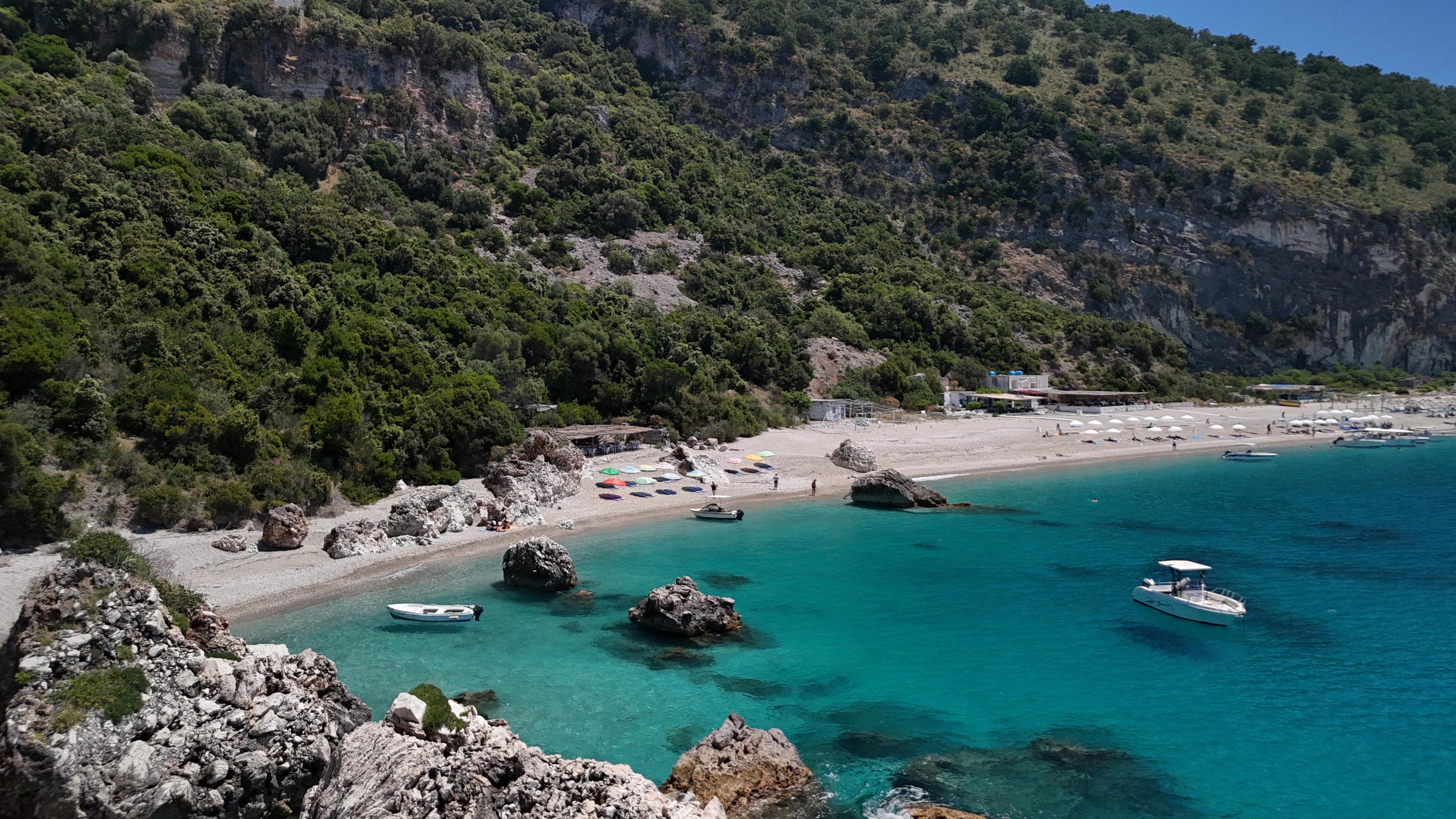Luchtfoto van boten die langs de kust van Sarande varen.