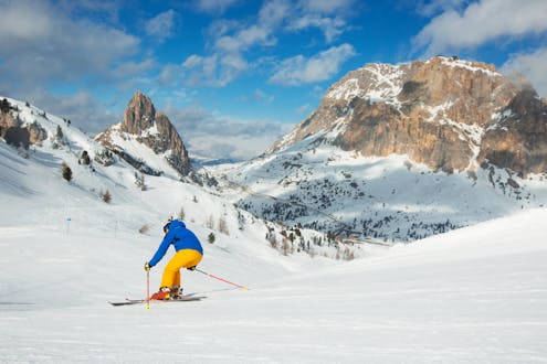 Adultes et enfants skiant dans la station de ski de Dobbiaco.