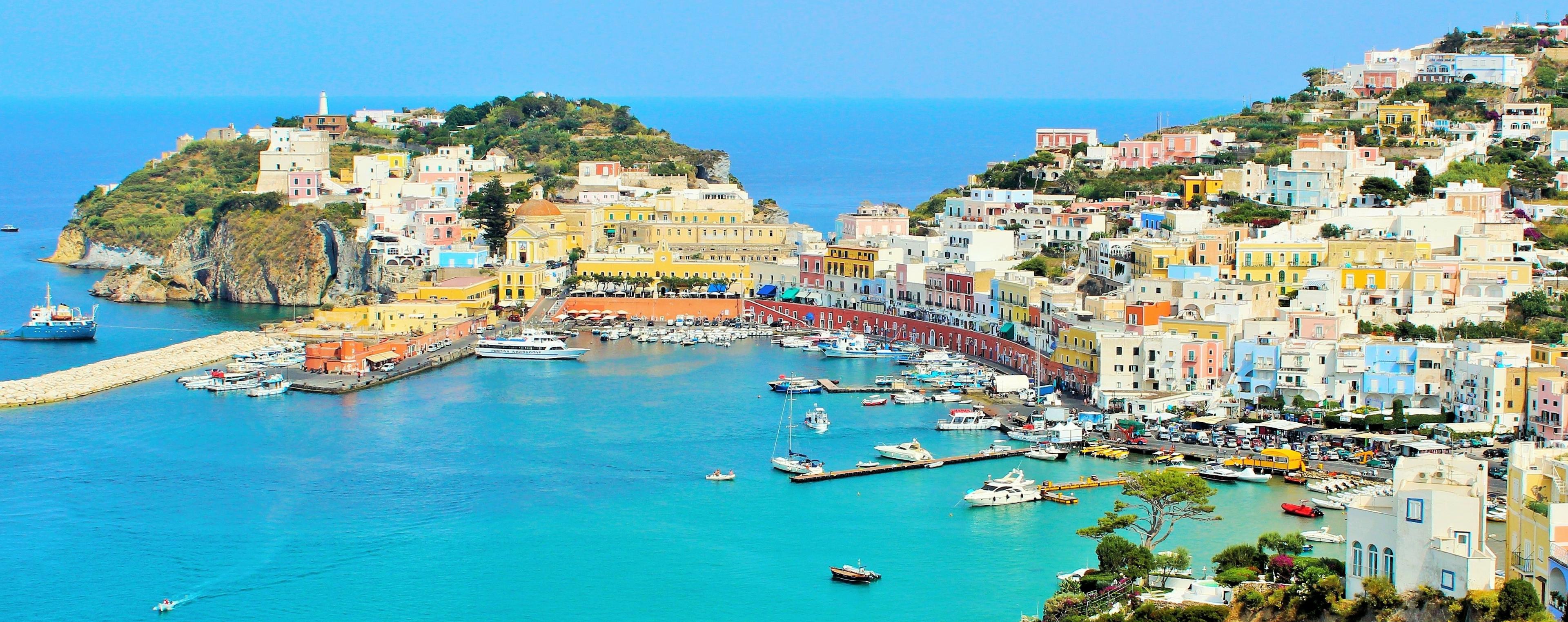 Port coloré de Ponza, Italie, avec des bateaux amarrés et des maisons pastel sur la colline.