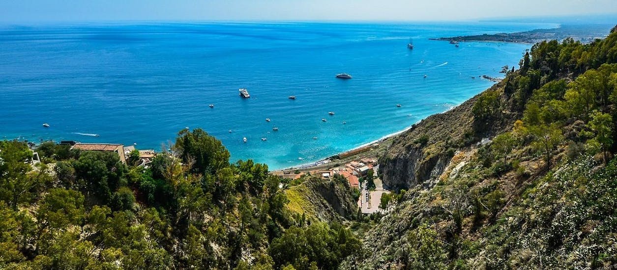 Foto panoramica mozzafiato della costa di Taormina, visitabile durante un giro in barca con Enjoy Sicily.