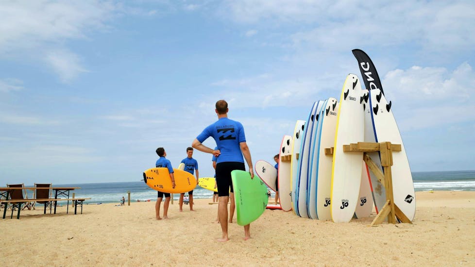 Participants are getting ready for their surfing lessons with the ESCF Anglet-Seignosse surf schools.
