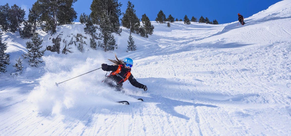 A ski instructor from Escuela Ski Cerler skies down the snowy slopes in a sporty and skillful way.