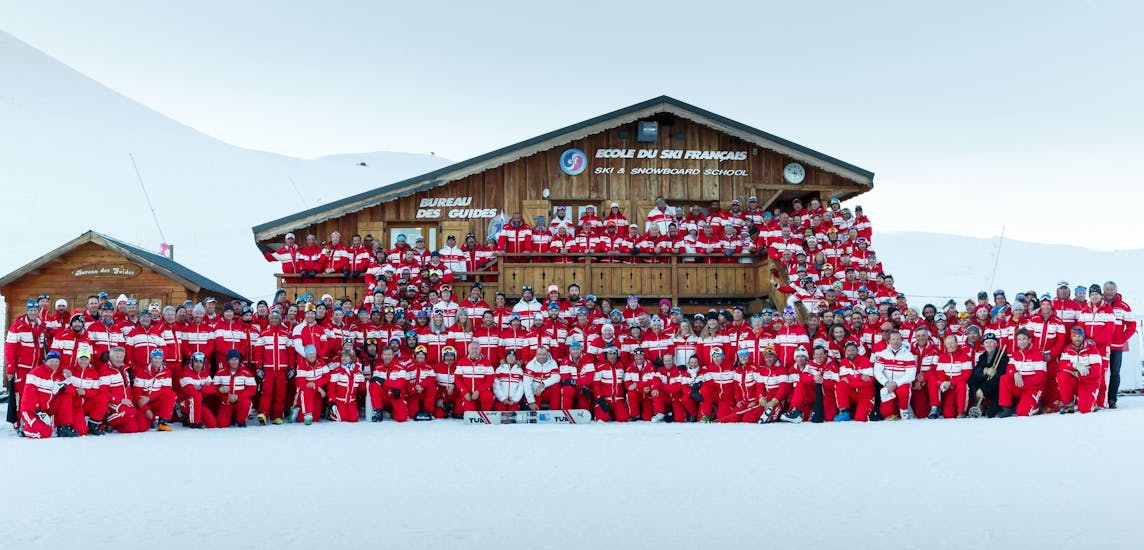 L'équipe complète de l'école de ski ESF Alpe d'Huez prend la pose pour une photo de groupe devant l'un des chalets de la station de ski Alpe d'Huez.