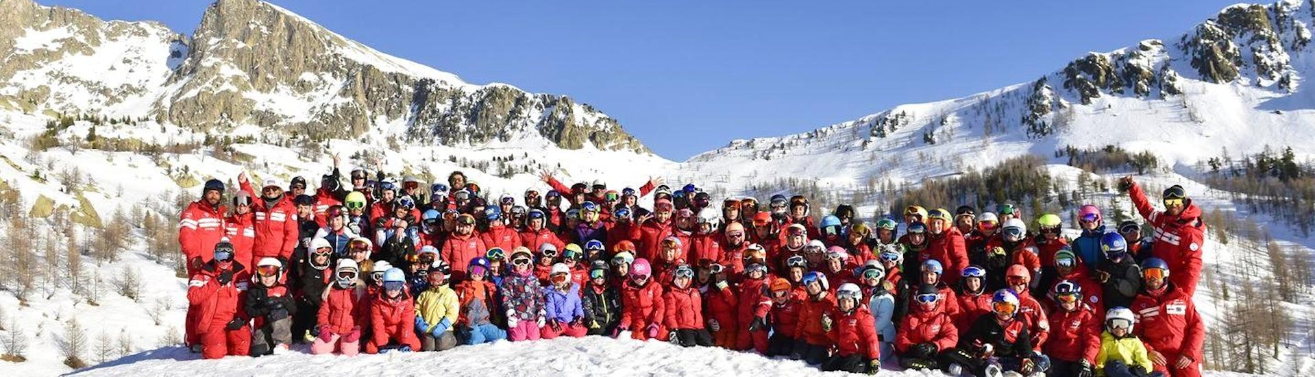 Ski instructors of the ski school ESF Isola 2000 and kids are posing for a group picture before the start of their ski lessons.
