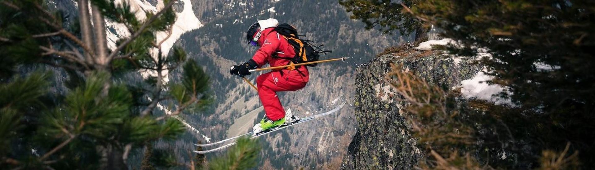Un skieur hors piste en train de sauter d'un rocher pendant un cours de ski freeride avec l'école de ski ESF Vallorcine dans la station de ski de Chamonix.