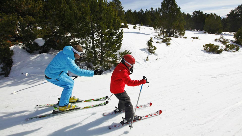 Un jeune skieur suit les instructions de son moniteur de ski de l'école de ski ESI Font Romeu sur l'une des pistes enneigées de la station de ski Font Romeu dans les Pyrénées.