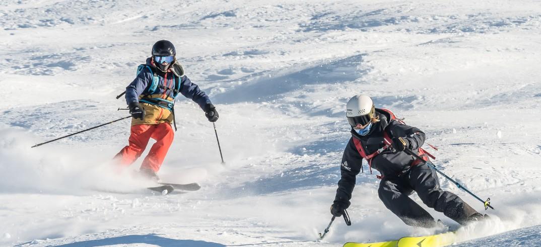 A ski instructor of  Evolution 2 Les Gets skiing with a participant.