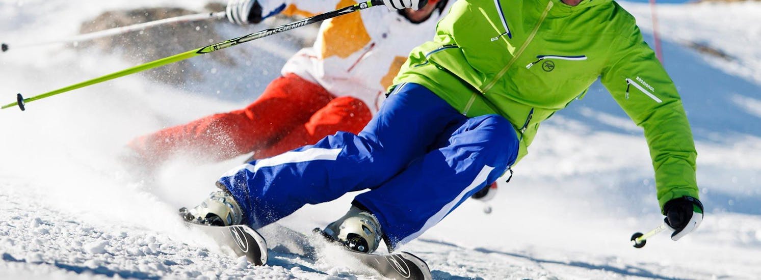 Deux skieurs sont au milieu d'un virage carving pendant un de leurs cours de ski avec l'école de ski Evolution 2 Morzine.