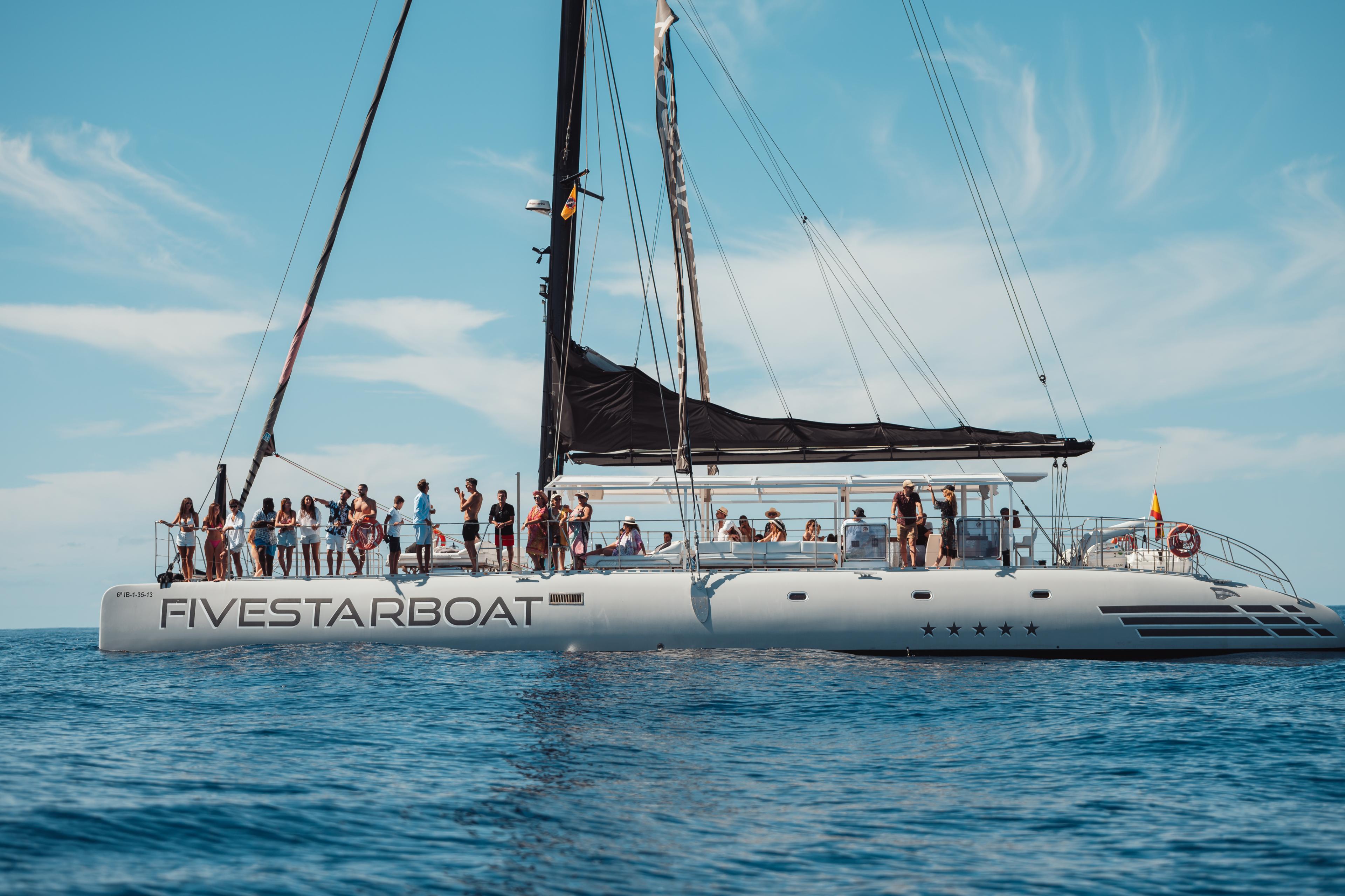 Una bella barca a vela sulla costa di Tenerife con persone.