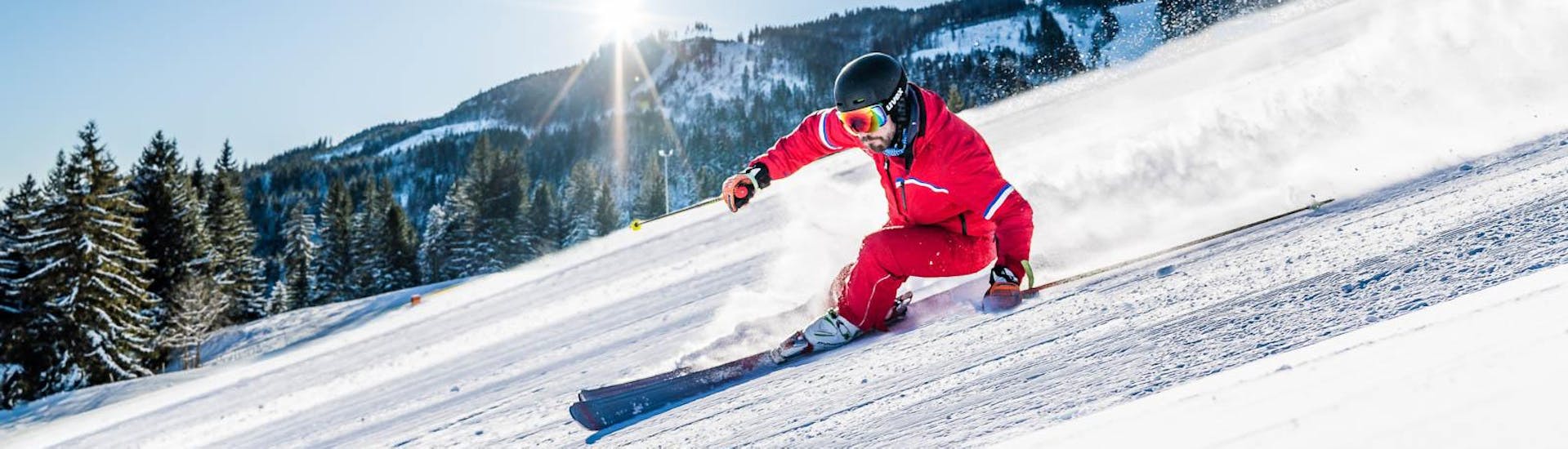 Een instructeur van Skischool Nesselwang die op een zonnige dag van de piste afgaat.