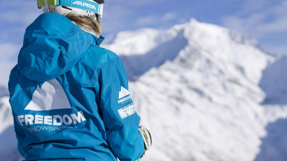 Eine Skilehrerin der Skischule Freedom Snowsports blickt über die verschneite Berglandschaft im Skigebiet Chamonix.