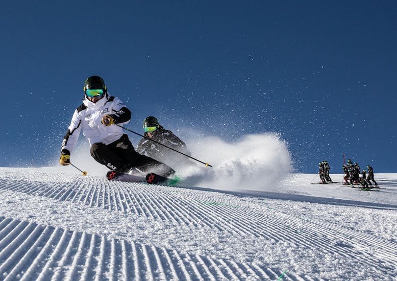 Des skieurs dévalent une piste de Crans-Montana pendant un cours de ski avec la Giorgio Rocca Sky Academy. 